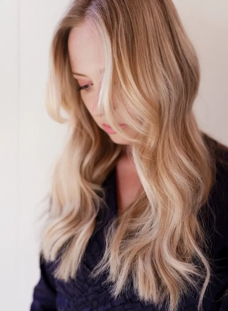 Vrouw met lange, golvende blonde haarextensions gestyled door kapper James bij Twiggy.