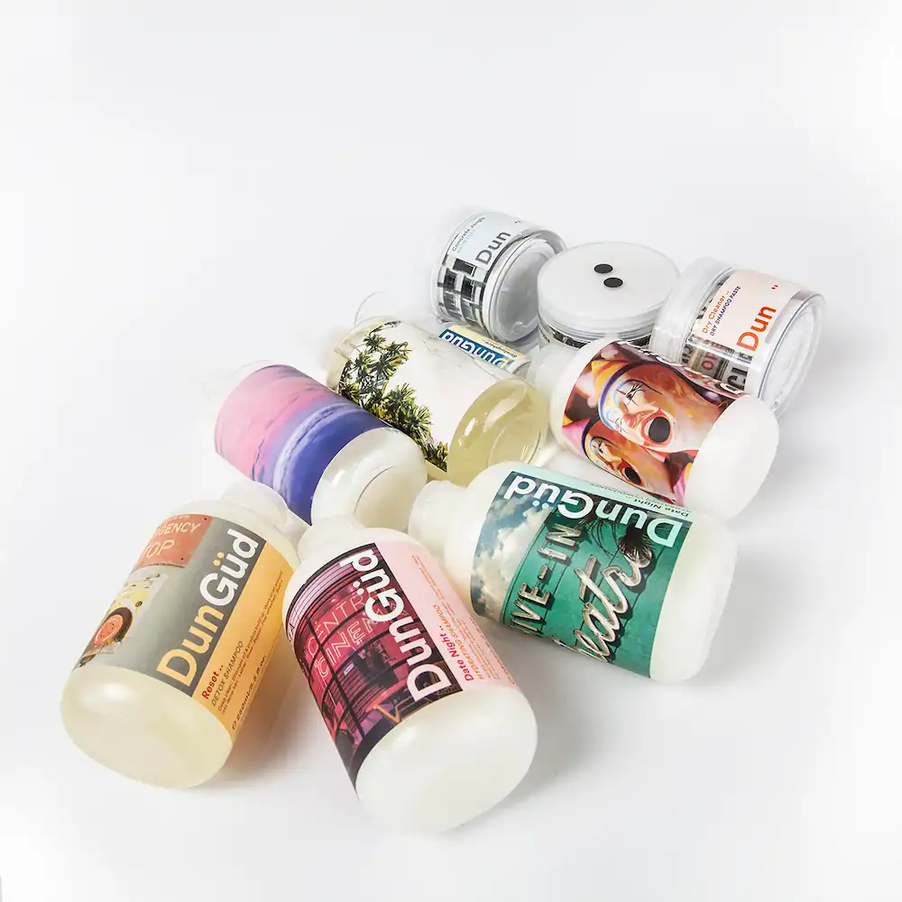 Een bundel van verschillende DunGüd-productflessen en -potjes met kleurrijke etiketten op een witte ondergrond.