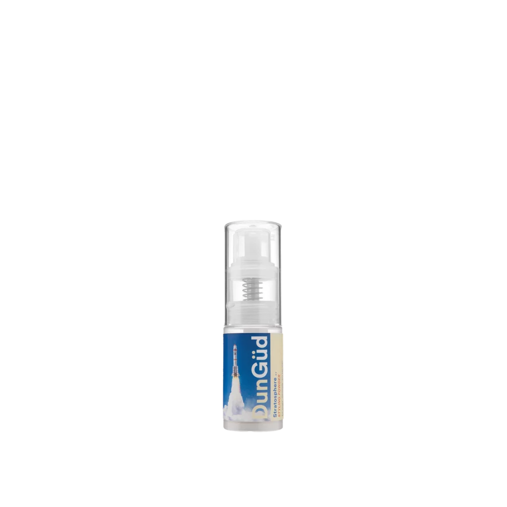 Transparante fles met DunGüd Stratosphere Styling Powder en een raketillustratie op het etiket.